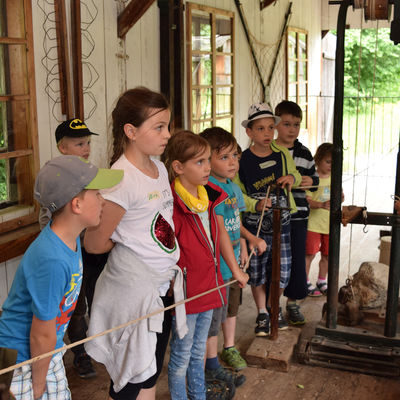 Kinder schauen bei der Herstellung eines Seiles in der Werkstatt zu. <br/> © Bezirk Oberbayern, Bauernhausmuseum Amerang
