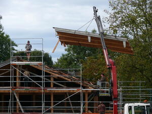 Beim Rückbau des Wirtschaftsteils am Bartlhof wird das Dach in mehreren Elementen heruntergehoben. <br> © Bezirk Oberbayern, Archiv BHM Amerang