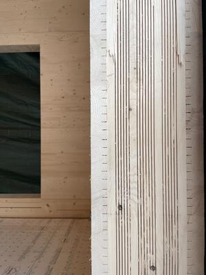 Ein Blick in die dreilagige Struktur der Starkholzplatten zeigt mehrfach geschlitzte Holzprofile, die lösungsmittelfrei verleimt sind. <br> © Bezirk Oberbayern, Archiv BHM Amerang